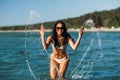 woman in bikini splashing sea water on beach Royalty Free Stock Photo