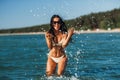 woman in bikini splashing sea water on beach Royalty Free Stock Photo