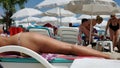People sunbathe on beach in summertime