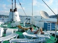 People sunbathe on sunbeds on the deck of the ship