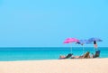 People sunbathing and relaxing on beach chairs.