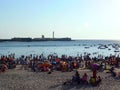 People sunbathing at sunset on the beach of La Caleta in the bay of Cadiz, Andalusia. Spain.