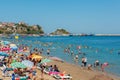 People sunbathing walking or swimming in a very crowded day in Amasra beach