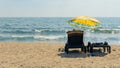 people on sunbeds under an umbrella relax on the beach against the sea Royalty Free Stock Photo