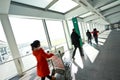 People in sunny windows modern airport station aisle Royalty Free Stock Photo