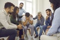 People supporting and comforting a crying young man during a group therapy session Royalty Free Stock Photo