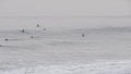 People surfing in cold ocean water. Surfers waiting, catching sea wave, standing on surfboard. California USA Royalty Free Stock Photo