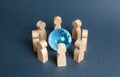 People surrounded a blue glass globe. Concept of cooperation and collaboration of people and countries around the world. Royalty Free Stock Photo