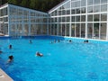 People swim in the outdoor pools against the backdrop of the picturesque scenery of the ski resort in the summer. Russia, Royalty Free Stock Photo