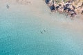 People swim or relax, turquoise sea water and sandy beach with rocks, aerial view. Summer vacation Royalty Free Stock Photo