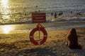 People swim in sunset sea right at the prohibitory sign Royalty Free Stock Photo