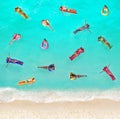 People swim in water on the beach with inflatable