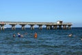 People swimming in front of a pier in Fort Lauderdale