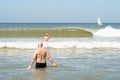 People swimming in the sea water, towards big waves - concept of drowning danger and safe summer at the beach. No recognizable peo