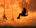 people on swings silhouetted against a cloudy sky Royalty Free Stock Photo