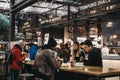 People at the tables inside Spitalfields Market, LOndon, UK, selective focus