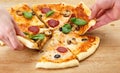 People take pizza slices with cheese, mushrooms, salami