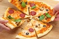 People take pizza slices with cheese, mushrooms, salami