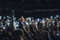 People taking photographs with smart phone during a music concert. Person capturing a video on a mobile phone at a music festival.