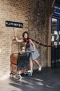 People taking photos by 9 3/4 platform inside King`s Cross stati