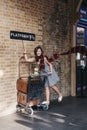 People taking photos by 9 3/4 platform inside King`s Cross station, London, UK. Royalty Free Stock Photo