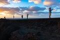 People taking photos on their phones at Amazing Los Hervideros lava caves in Lanzarote island at sunset, popular touristic