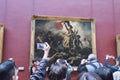 People taking pictures of Delacroix painting