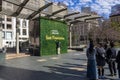 people taking pictures in front of a wall covered in lush green plants with the Union Square sign with red and green trees Royalty Free Stock Photo