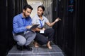 People, talking and technician in server room with tablet for cybersecurity, update or team problem solving in data or Royalty Free Stock Photo