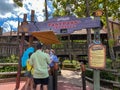 People talking to a cast member at the Splash Mountain ride wearing face masks and social distancing at Walt Disney World in