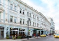 People and taxi cars on Myasnitskaya street with the view of Spiridonov former revenue house and summer cafe in Moscow