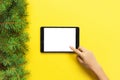 People and technology concept, close up of female hands pointing finger to tablet. blank screen on yellow background, top view Royalty Free Stock Photo