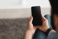 People and technology concept. Over the shoulder view of guy using smartphone with blank screen for mockup