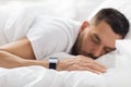 Close up of man with smart watch sleeping in bed