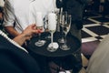 people toasting with champagne glasses at wedding reception, waiter serving on tray champagne drinks, celebration catering