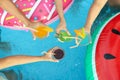 People toasting with refreshing drinks at pool party