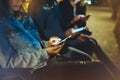 People together pointing finger on screen smartphone on background bokeh light in night atmospheric city, group adult hipsters fri Royalty Free Stock Photo