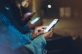 People together pointing finger on screen smartphone on background bokeh light in night atmospheric city, group adult hipsters Royalty Free Stock Photo