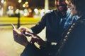 People together pointing finger on screen smartphone on background bokeh light in night atmospheric city, group adult hipsters