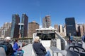 People on the Top Deck of a Ferry Boat on the East River with a view of the Manhattan Skyline