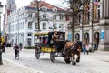 People touring around the beautiful Bruges town on a carriage pulled by a horse