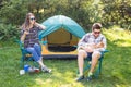 People, tourism and nature concept - Couple having fun on camping trip Royalty Free Stock Photo