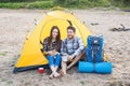 People, tourism and nature concept - Couple having fun on camping trip with cat Royalty Free Stock Photo