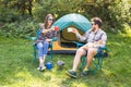 People, tourism and nature concept - Couple having fun on camping trip and play with cat Royalty Free Stock Photo