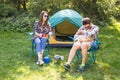 People, tourism and nature concept - Couple having fun on camping trip and play with cat Royalty Free Stock Photo