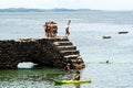 People and tourists are on top of the stone pier of Porto da Barra