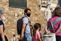 People, tourists walking in the square next to David sculpture wearing face masks during covid 19 quarantine in Italy.