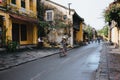 people in traditional hats riding bicycles on street in Hoi An, Vietnam Royalty Free Stock Photo