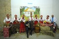 People in traditional Ukrainian clothes playing folk instruments at a hall. Outlook world culture festival