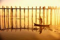 People traveling across the U Bein Bridge in the evening. Mandalay Myanmar with sunset